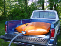 Rubber sack on back of bakkie filled with petrol, and attached to the petroltank inlet.